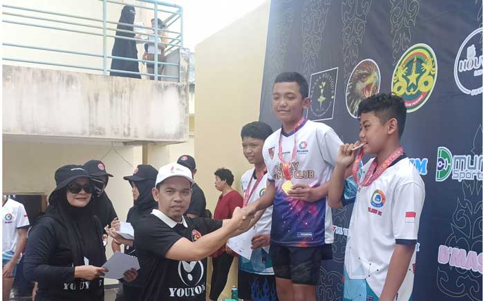 Kadispora Riau, Erisman Yahya bersalaman dengan atlet renang Usai mengalungkan medali pada Kejuaraan Riau Aquatic Junior Sprint V 2024, Sabtu (2/3/2024) bertempat di Aquatic Centre - Sport Centre