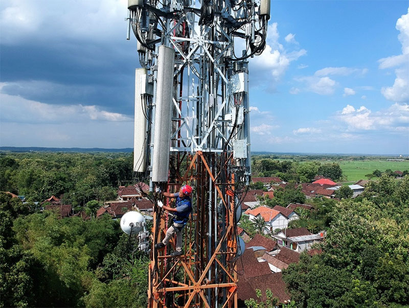 Seorang teknisi sedang memperbaiki jaringan XL Axiata di sebuah menara di kawasan Danau Toba, Sumatra Utara, belum lama ini.