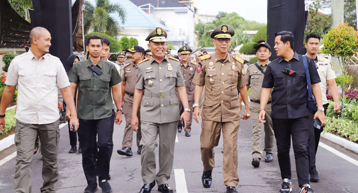 Pj Bupati Inhil H Herman didampingi Kasatpol PP Inhil H Yuspik, berjalan menuju lokasi puncak HUT Satpol PP 2024 di Padang, Ahad (3/3/2024).