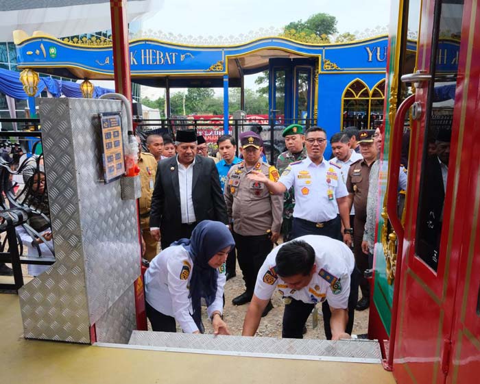 Pegawai Dishub memperlihatkan tangga bus wisata Siakuw kepada Bupati Siak Alfedri di halaman MPP Siak, Senin (4/3/2024). Tangga ini aman untuk lansia, penyandang disabilitas dan anak anak.
