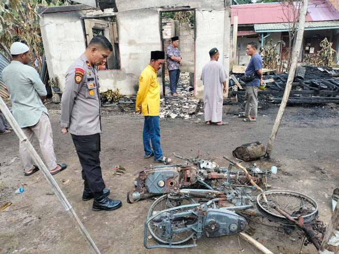 Sejumlah masyarakat saat melihat sisa-sisa puing dari terbakarnya satu unit rumah di Desa Sepahat, Kecamatan Bandar Laksamana,  Bengkalis,  Senin (4/3/2024).