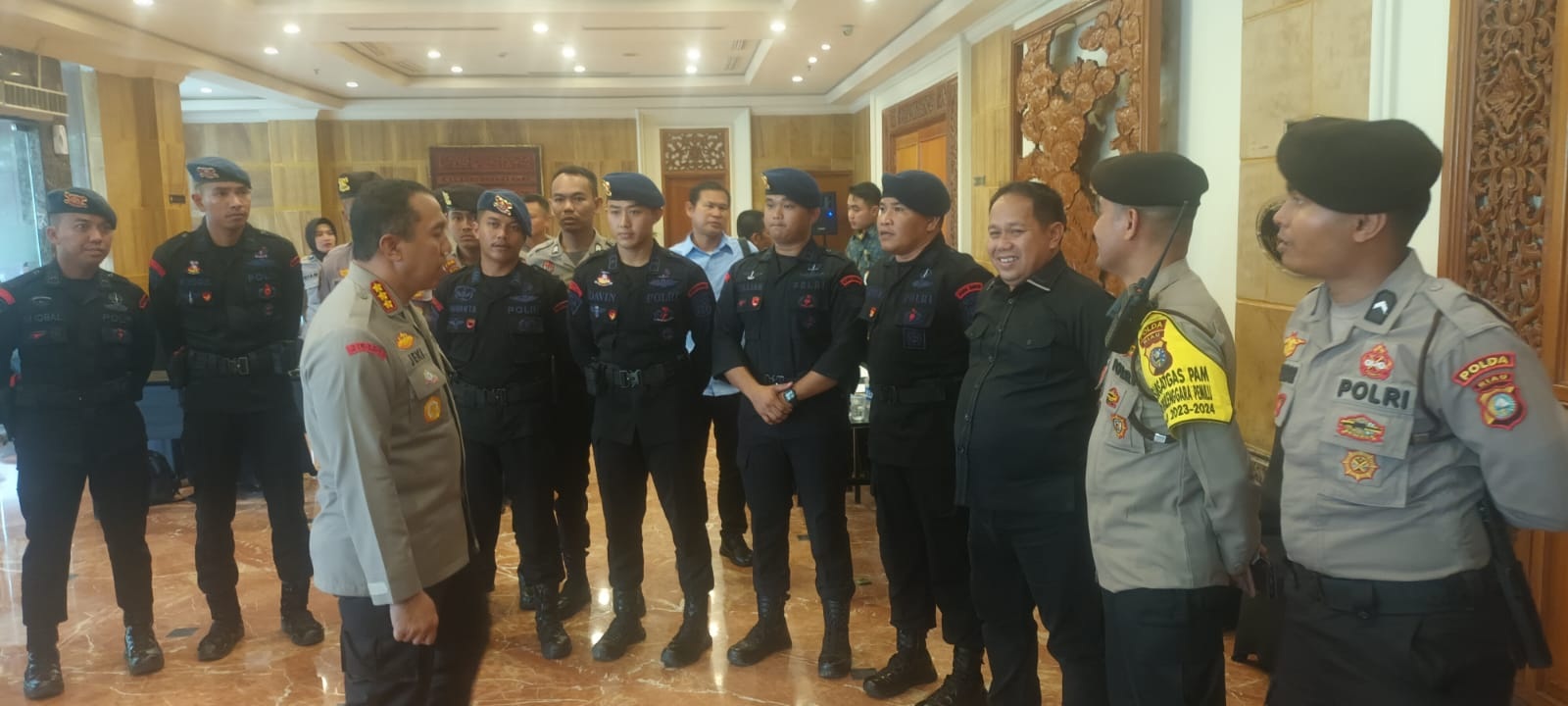 Kapolresta Pekanbaru Kombes Pol Jeki Rahmat Mustika memberikan arahan ke personel Brimob yang berjaga di luar ruang sidang pleno KPU Riau di Hotel Aryaduta Pekanbaru, Kamis (7/2/2024).