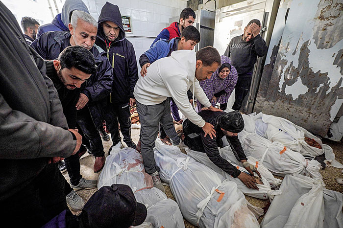 Warga Palestina saat  melihat jenazah keluarganya yang tewas dan jadi korban pemboman Israel di rumah sakit al-Aqsa, Deir el-Balah, Jalur Gaza tengah, Rabu (6/3/2024).
