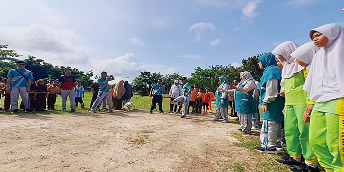 Ketua K3S Kecamatan Rumbai Barat Saiful SPd MM menendang bola sebagai tanda dimulainya O2SN jenjang SD tahun 2024 di halaman SDN 182 Pekanbaru,