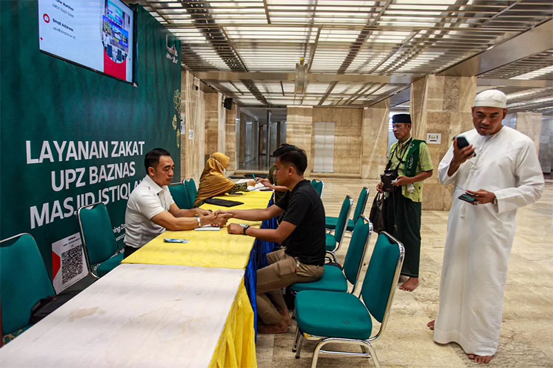 Petugas Amil Zakat melayani umat Islam yang membayar zakat fitrah di Masjid Istiqlal, Jakarta, Kamis (20/4/2023).