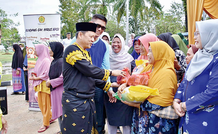 Pj Bupati Kampar H Hambali menyerahkan sembako pada warga saat pasar murah di Desa Batu Belah, Kecamatam Kampar, Kabupaten Kampar, Sabtu (9/3/2024).