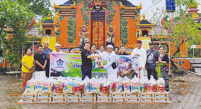 Ketua Bidang Sosial PSMTI Kota Pekanbaru Ng Dju Khiong (kiri depan) menyerahkan paket nyepi kepada Pinandita Kawit SAg (kanan depan) di Pure Agung Jagatnatha, Sabtu (9/3/2024).