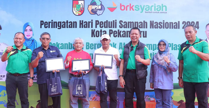 Sekdako Pekanbaru Indra Pomi Nasution dan Plt Kadis DLHK Ingot Ahmad Hutasuhut foto bersama  usai menyerahkan sertifikat penghargaan kepada penggiat program kampung iklim Pekanbaru.
