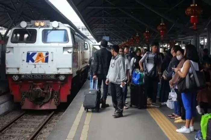 Penumpang menunggu kedatangan kereta api di Stasiun Surabaya Gubeng.