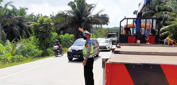 Personel Satuan Lantas Polres Pelalawan melakukan pengaturan lalu lintas di Jalintim KM 36,  yang masuk dalam daerah rawan macet guna menciptakan keamanan, dan kelancaran lalu lintas, Ahad (17/3/2024)