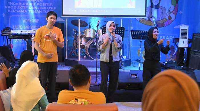 Ketua Dewan Pembina Sign Of Solidarity (SOS) sekaligus Wasekjen DPP Golkar, Lindsey Afsari Puteri saat menyanyikan lagu dengan bahasa isyarat .