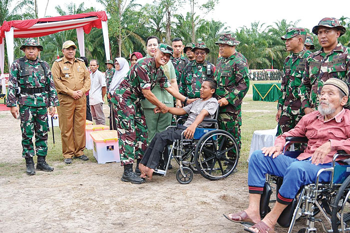 Irjenad Letnan Jenderal TNI Erwin Djatniko SSos bersama istri menyerahkan kursi roda bagi penyandang disabilitas saat penutupan TMMD, Rabu (20/3/2024).