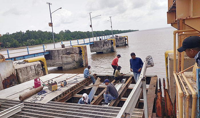 Para pekerja sedang memperbaiki bagian ram mobile bridge Dermaga Ro-Ro Air Putih-Sungai Pakning yang mengalami pengeroposan, Rabu (20/3/2024).