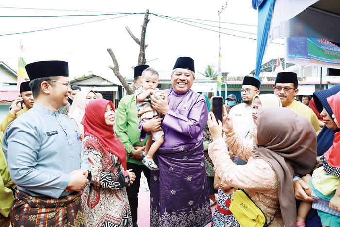 Bupati Siak didampingi Kadiskes menyerahkan bantuan paket dari PT BSP saat Bujang Kampung ke-100 di Kelurahan Perawang, Kecamatan Tualang, Jumat (8/3/2024).