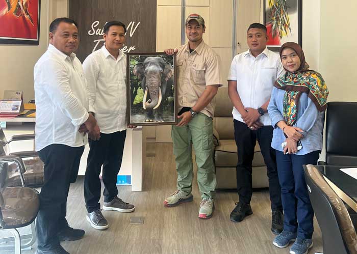 Aktor Chicco Jerikho menyerahkan foto Gajah Rahman yang mati di kawasan konservasi Taman Nasional Tesso Nilo kepada Kasubdit IV Ditreskrimsus Kompol Nasruddin, Senin (25/3/2024).