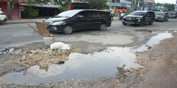 Warga memberi tanda di Jalan Ahmad Yani yang mengalami kerusakan, Senin (25/3/2024). Kerusakan ini sudah berlangsung lama, namun belum ada upaya perbaikan dari pihak terkait.