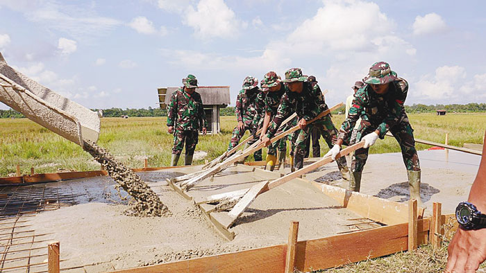 Personel TNI AD saat melakukan pengecoran Jalan Dewi Sri sepanjang 1,420 km dalam rangkaian TMMD ke-119 di Kampung Sungai Tengah, Kecamatan Sabak Auh, Kabupaten Siak, Kamis (22/2/2024).