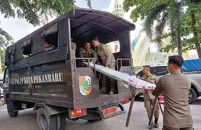 Petugas Satpol-PP melakukan penertiban kepada pelaku usaha rumah makan di Jalan Hang Tuah, Pekanbaru, yang nekat buka pada siang hari selama Ramadan. Foto diambil baru-baru ini.