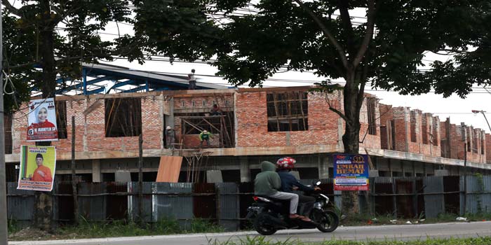 Para pekerja mengebut pembangunan Pasar Induk yang sudah hampir rampung, Rabu (27/3/2024).