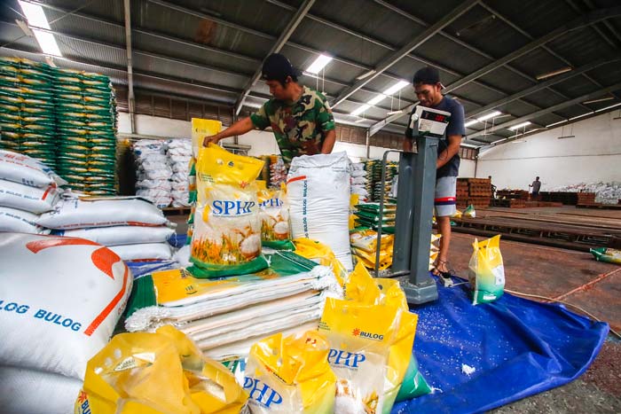 Pekerja melakukan pengemasan beras Bulog atau beras Stabilisasi Pasokan dan Harga Pangan (SPHP) di Gudang Bulog Wilayah Riau-Kepri, Pekanbaru, belum lama ini.