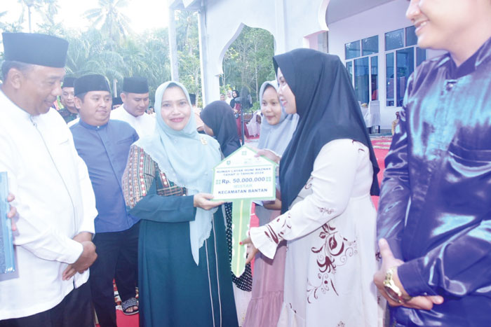 Bupati Bengkalis Kasmarni menyerahkan kunci rumah secara simbolis program bedah rumah Baznas  saat Safari Ramadan di Masjid At-Taqwa Desa Bantan Sari, Bengkalis, Sabtu (30/3/2024).