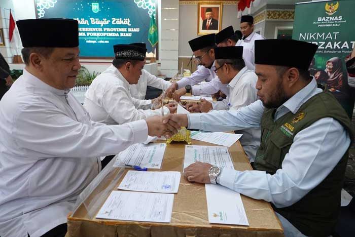 Pj Gubri SF Hariyanto menyerahkan zakat ke Baznas Riau yang diterima Ketua Baznas Riau, Masriadi Hasan di gedung daerah Riau, Senin (1/4/2024).