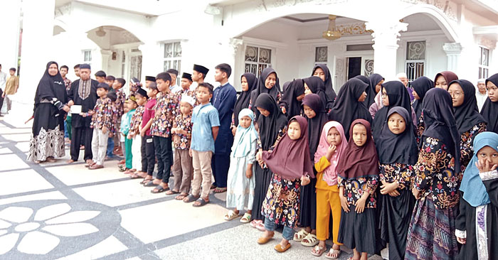 Direktur PT Lestari Putra Perkasa H Ahmad dan istri foto bersama anak yatim saat memberikan santunan, Ahad (31/3/2024).
