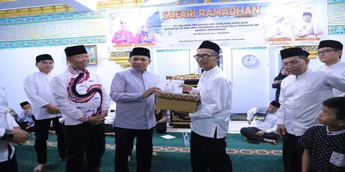 Pj Wako Pekanbaru Muflihun (tiga kiri) didampingi Sekko Indra Pomi Nasution (dua kiri) berikan bantuan saat Safari Ramadan di Masjid Al-Iradah, Jalan ahmad yani,gang tarandam kelurahan pulau koramah