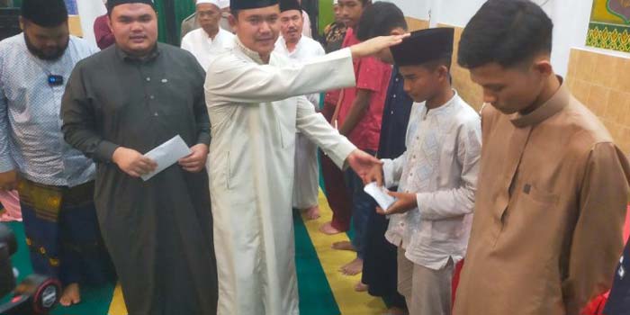 Kades Muara Basung Akhyar menyerahkan santunan kepada anak yatim pada malam peringatan Nuzulul Qur&rsquo;an di Masjid At-Taqwa, Desa Muara Basung, Kecamatan Pinggir, Ahad (31/3/2024) malam