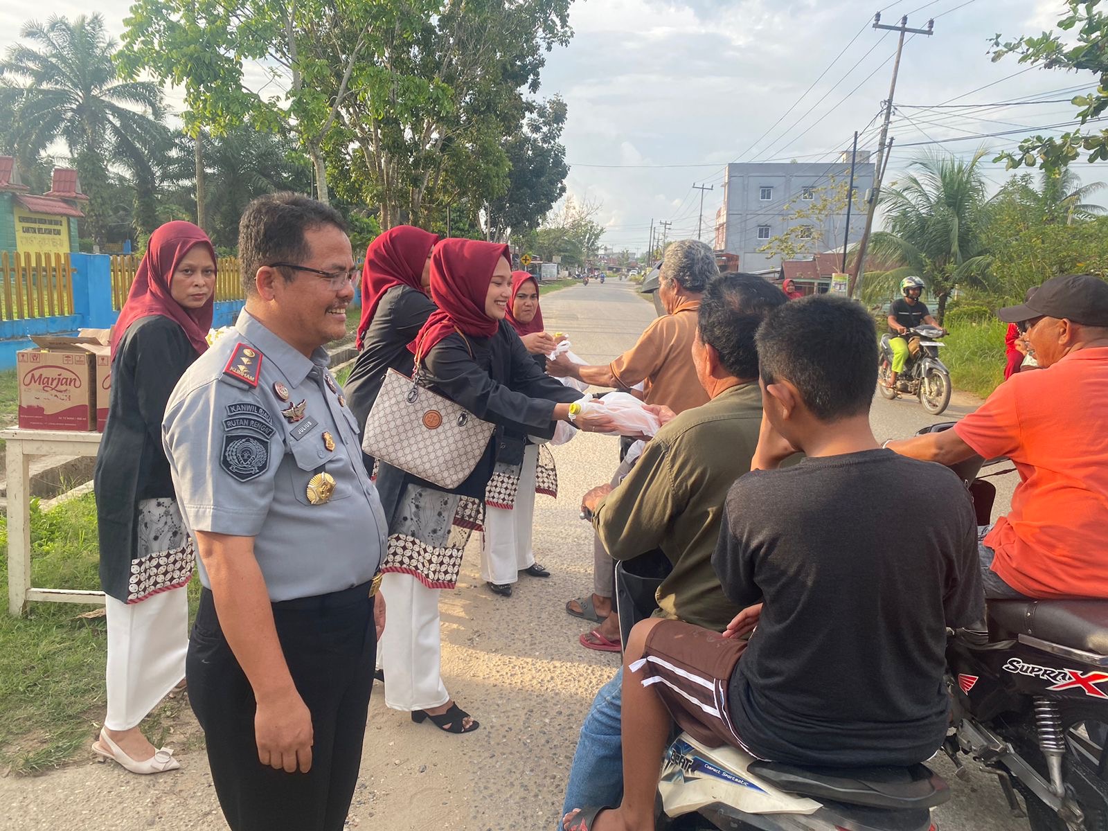 Kepala Rutan kelas IIB Rengat, Julius Barus SE MH menyerahkan Takjil kepada warga yang melintas di depan Kantor Rutan kelas IIB Rengat, Senin (1/4/2024).