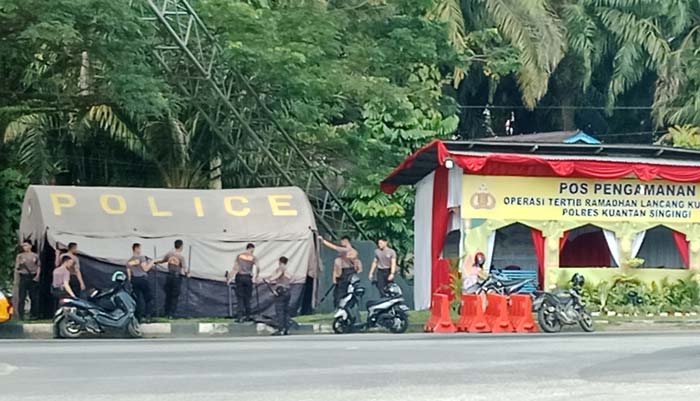 Personel Polres Kuantan Singingi mendirikan tenda Pos Pengamanan Operasi Lancang Kuning 2024 di Simpang Tugu Cerano, Telukkuantan, Kuantan Singingi, Selasa (2/4/2024).