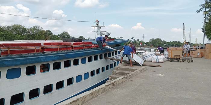 Pekerja menaikkan barang bawaan masyarakat ke atas Kapal Jelatik di Pelabuhan Sungai Duku, Pekanbaru, Selasa (2/4/2024).