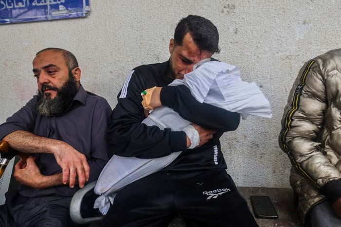 Seorang ayah menangis saat memegang jenazah salah satu dari dua anaknya  yang terbunuh dalam serangan udara Israel di Rafah, Jalur Gaza Selatan, Kamis (4/4/2024).