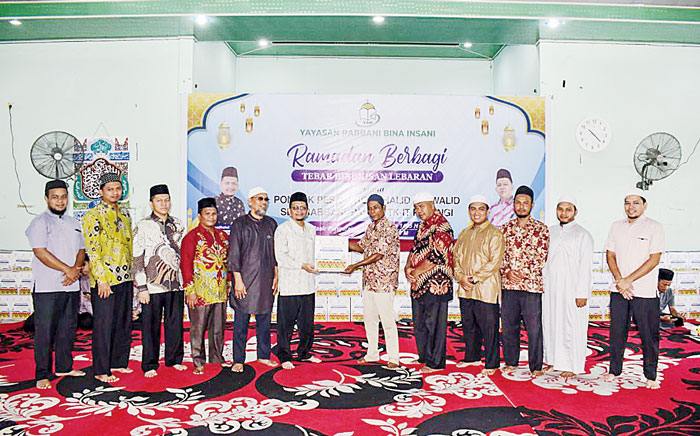 Ketua Yayasan Rabbani Bina Insani H Roudhatul Firdaus Lc saat menyerahkan bingkisan Idulfitri dari YRBI kepada perwakilan RW dan RT untuk diserahkan kepada masyarakat, belum lama ini.