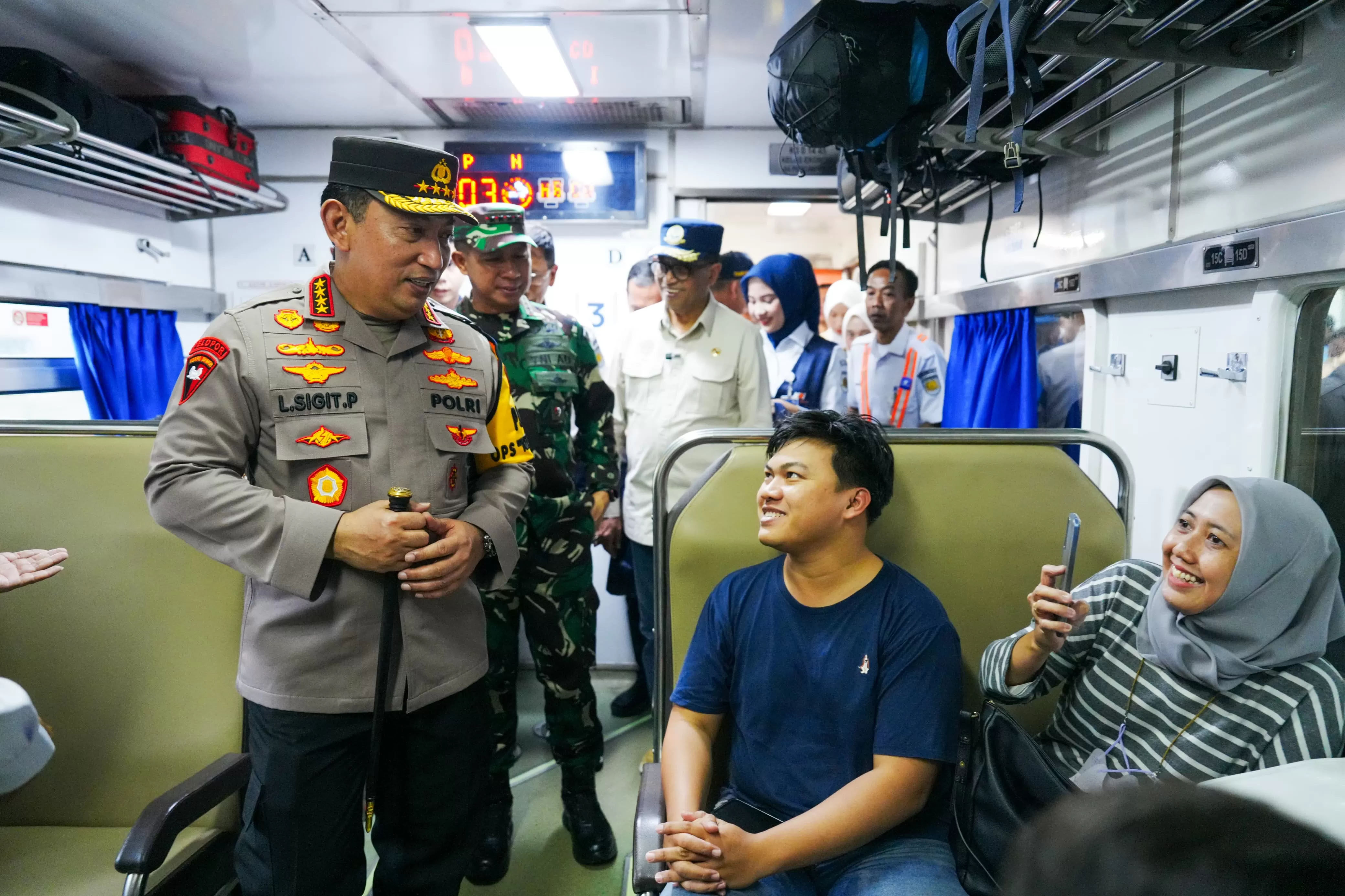 Kapolri Jenderal Listyo Sigit Prabowo berbincang dengan penumpang kereta api di Stasiun Pasar Senen.
