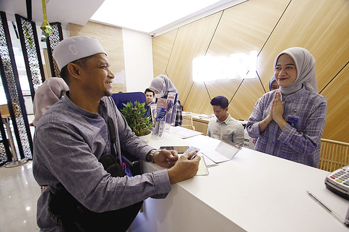 Karyawan Bank BRI RO Pekanbaru melayani nasabah di Menara BRI Jalan Sudirman Pekanbaru, Jumat (5/4/2024).