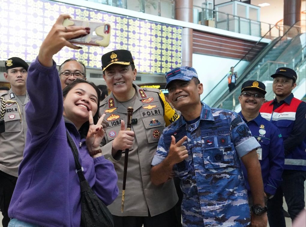 Kapolda Riau Irjen Pol Mohammad Iqbal dan Danlanud Roesmin Nurjadin Marsma TNI Feri Yunaldi berswafoto dengan masyarakat di Bandara SSK II Pekanbaru, Ahad (7/4/2024).