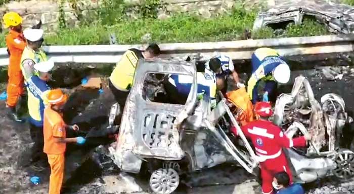 REMUK: Petugas berusaha mengevakuasi jenazah para penumpang Gran Max yang terbakar setelah terlibat kecelakaan di Km 58 Tol Jakarta-Cikampek kemarin (8/4).