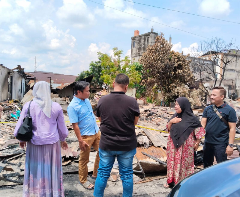 Kasat Reskrim Polres Rohul AKP Dr Raja Kosmos Parmulais terlihat sedang berbincang dengan sejumlah pedagang saat akan mendampingi Tim Labfor Polda Riau gelar olah TKP di Pasar Kelurahan Ujungbatu.