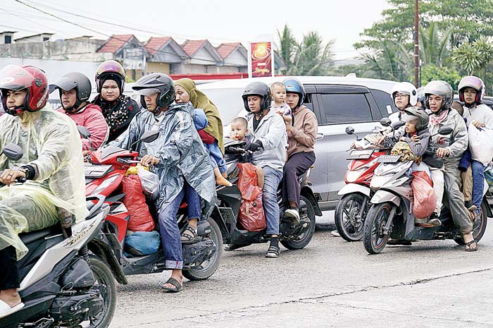 Pemudik yang menggunakan sepeda motor melintas di Jalan Raya Pekanbaru-Bangkinang.