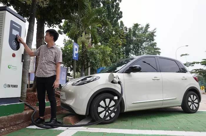 Pemilik Binguo EV mengisi daya pada fasilitas charging mobil listrik Wuling di Jakarta, belum lama ini.