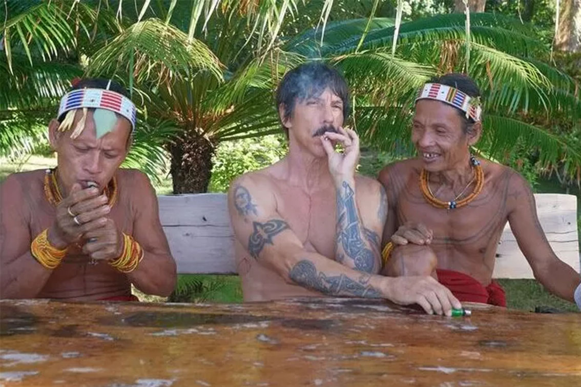 Vokalis RHCP, Anthony Kiedis, sedang menikmati tembakau bersama dua warga lokal Pulau Mentawai.