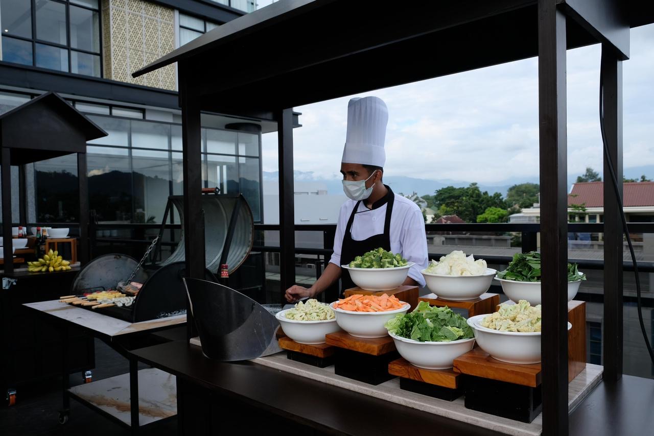 Koki di Kayu Manis Restaurant Hotel Santika Premiere Padang saat menyiapkan makanan.