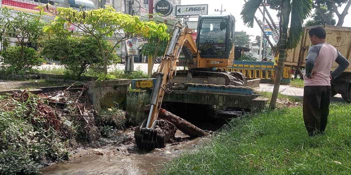 Petugas menggunakan alat berat melakukan pengerukan drainase, Jalan Arifin Achmad, Pekanbaru, Kamis (18/4/2024).