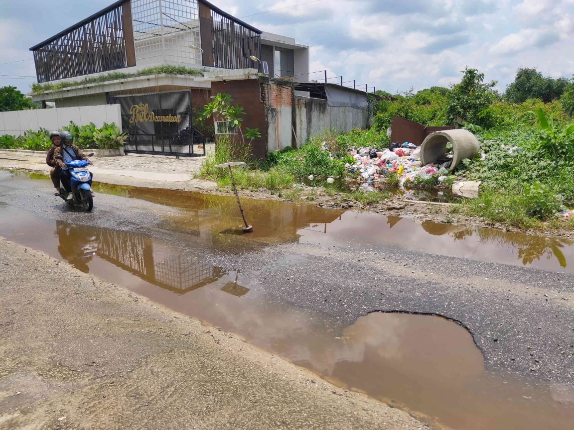 Kondisi tumpukan sampah dan banjir di Jalan Gulama Pekanbaru, Jumat (19/4/2024). Kondisi ini menyebabkan akses lalu lintas warga menjadi terganggu.