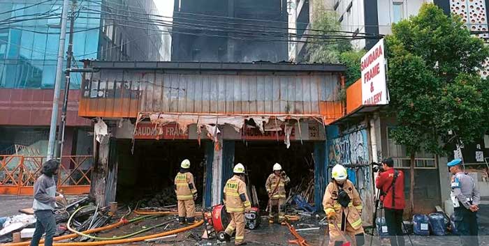 INSIDEN MAUT: Petugas melakukan pendinginan di ruko yang terbakar di Mampang Prapatan, Jakarta Seatan, Jumat (19/4).