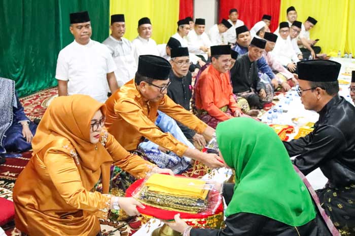 Kajati Riau Akmal Abbas (baju kuning), didampingi istri, saat menerima baju kebesaran adat dan tepak sirih dari MKA LAM Riau di rumah dinasnya pada Sabtu (20/4/2024),