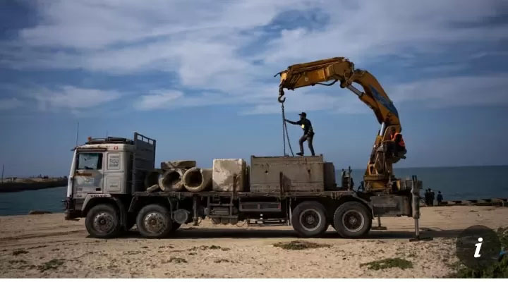 Warga Palestina membawa balok-balok semen ke dermaga yang dapat digunakan untuk membawa bantuan kemanusiaan ke Gaza pada bulan Maret.