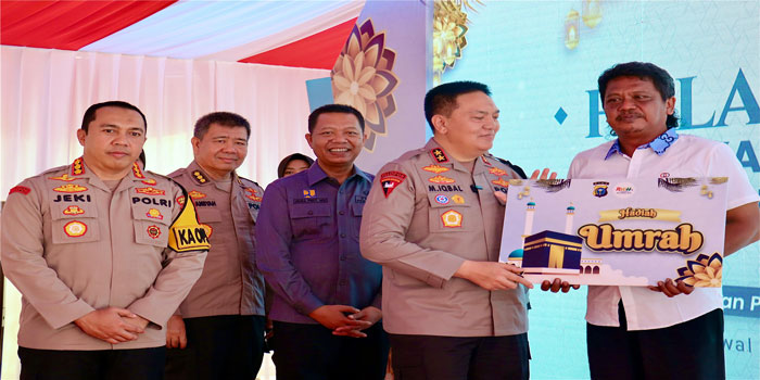 Kapolda Riau Irjen Mohammad Iqbal (dua kanan) menyerahkan hadiah umrah gratis kepada Aiptu Edy Jumarno (kanan) disaksikan Kapolresta Pekanbaru dan Sekko Pekanbaru di halaman Mapolresta Pekanbaru.