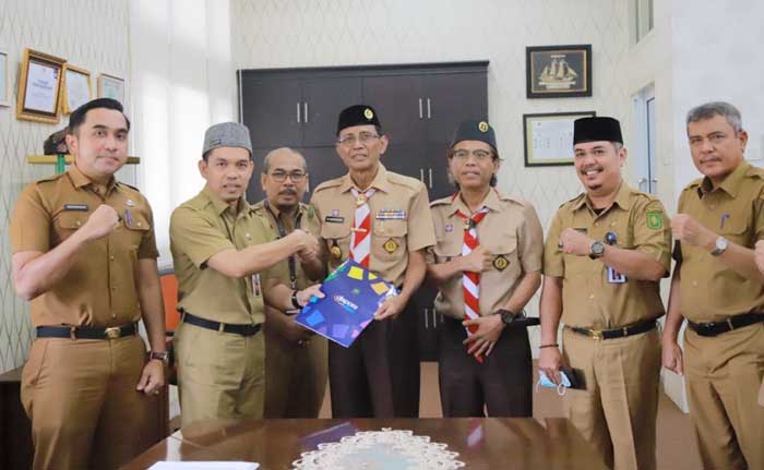 Kadispora Provinsi Riau H Erisman Yahya MH menyerahkan berita acara NPHD kepada Ketua Kwarda Gerakan Pramuka Provinsi Riau Kasiarudin SH, Senin (25/3/2024).